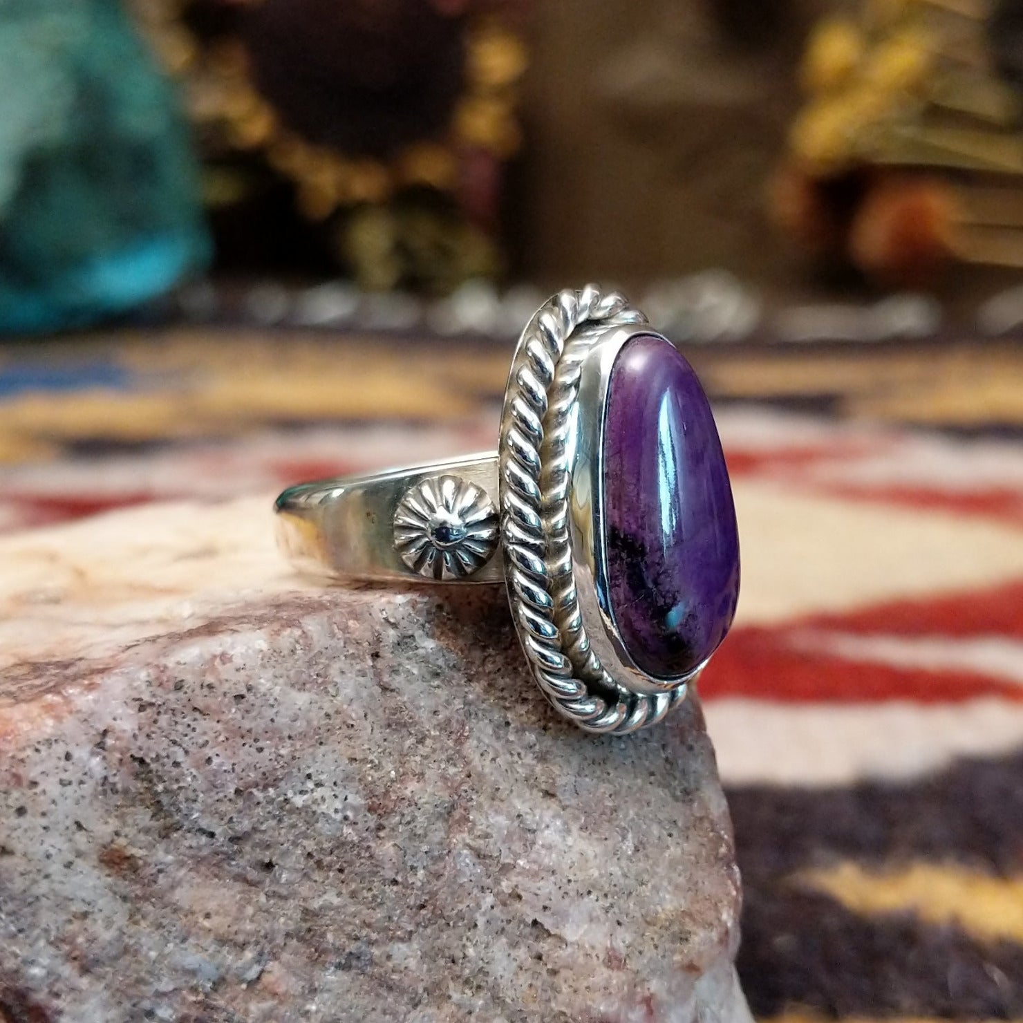Handcrafted sterling silver ovoid ring by Artie Yellowhorse featuring a deep purple sugilite stone in a polished Southwestern Native American design.  Side view.