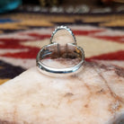 Handcrafted sterling silver ovoid ring by Artie Yellowhorse featuring a deep purple sugilite stone in a polished Southwestern Native American design.  Underside view.