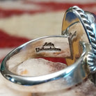 Handcrafted sterling silver ovoid ring by Artie Yellowhorse featuring a deep purple sugilite stone in a polished Southwestern Native American design.  Artisan stamp on band.