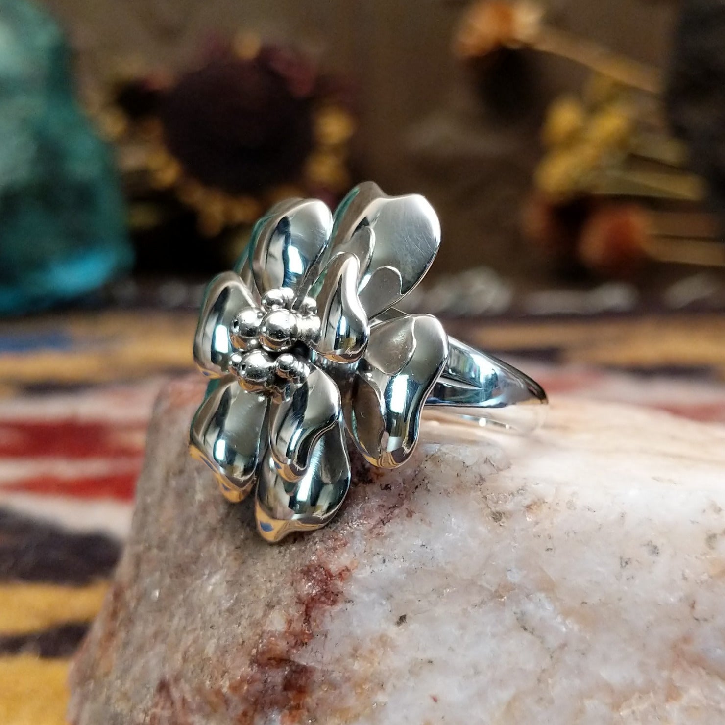 Handcrafted sterling silver dogwood flower ring by Artie Yellowhorse featuring polished floral detailing in a Southwestern Native American design.  Side view.