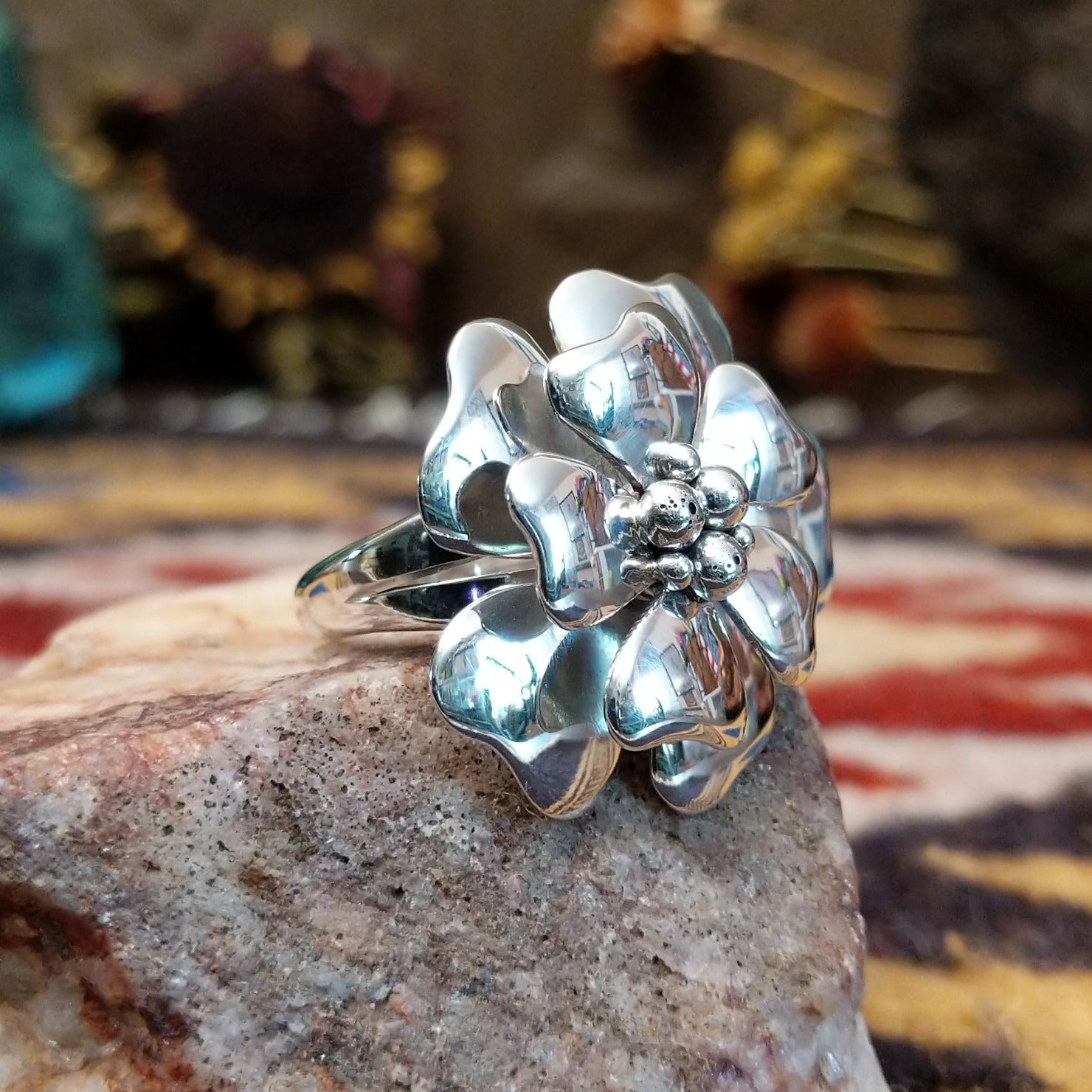 Handcrafted sterling silver dogwood flower ring by Artie Yellowhorse featuring polished floral detailing in a Southwestern Native American design.  Side view.