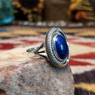 Handcrafted sterling silver oval ring by Artie Yellowhorse featuring a deep blue lapis stone in a polished Southwestern Native American design.  Side view.