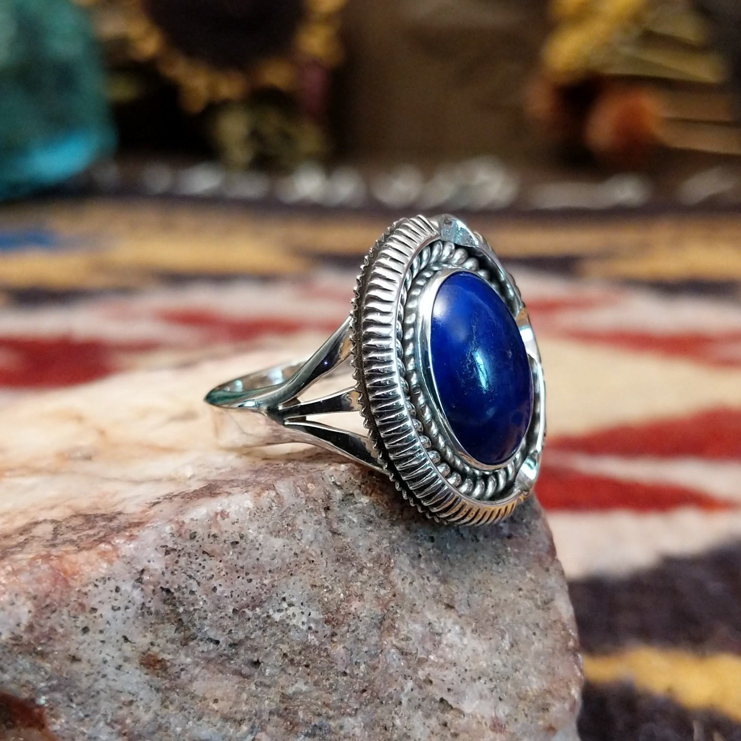 Handcrafted sterling silver oval ring by Artie Yellowhorse featuring a deep blue lapis stone in a polished Southwestern Native American design.  Side view.