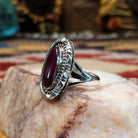 Handcrafted sterling silver ellipse ring by Artie Yellowhorse featuring a purple spiny oyster shell in a polished Southwestern Native American design.  Side view.