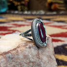 Handcrafted sterling silver ellipse ring by Artie Yellowhorse featuring a purple spiny oyster shell in a polished Southwestern Native American design.  Side view.