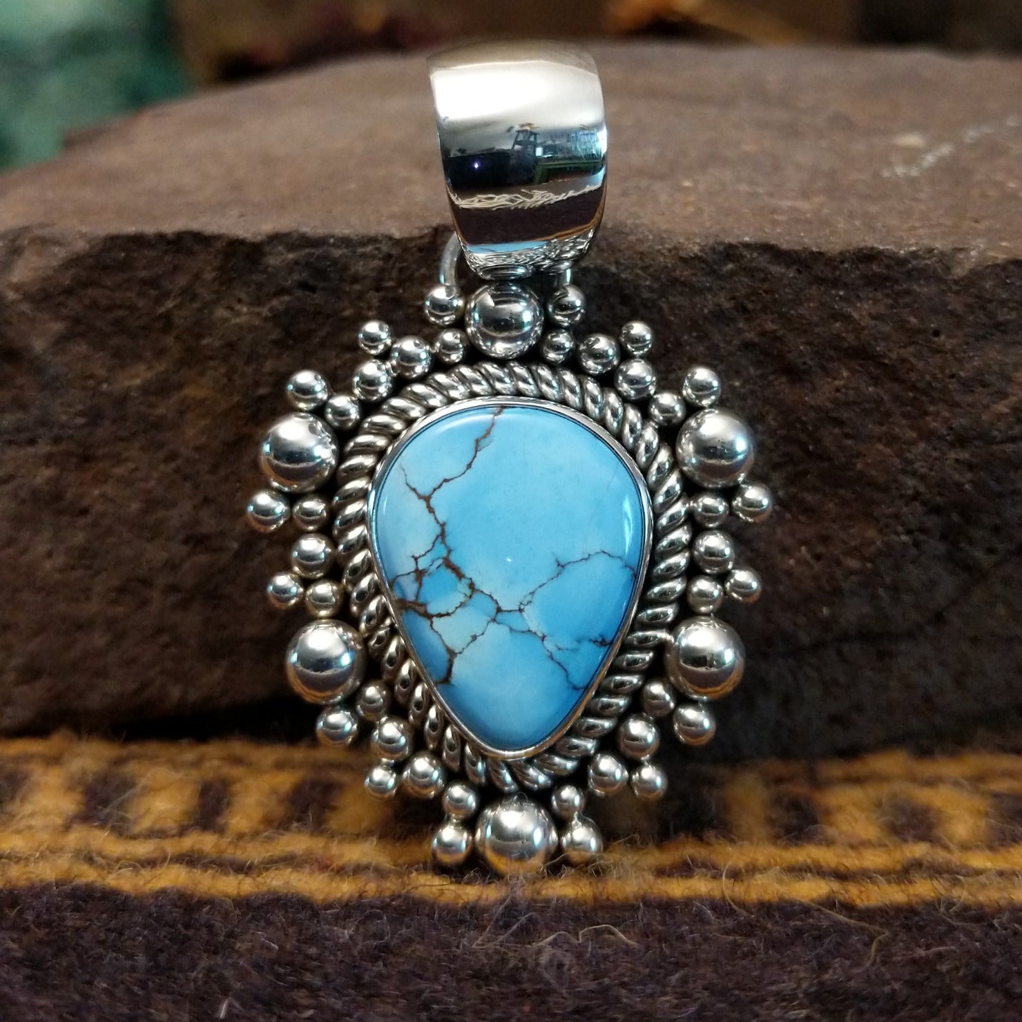 Handcrafted sterling silver pendant by Artie Yellowhorse featuring a Golden Hills turquoise stone in a polished Southwestern Native American design.