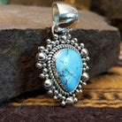 Handcrafted sterling silver pendant by Artie Yellowhorse featuring a Golden Hills turquoise stone in a polished Southwestern Native American design.  Side view.
