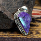 Handcrafted sterling silver pendant by Artie Yellowhorse featuring a deep purple sugilite stone in a polished Southwestern Native American design.  Side view.