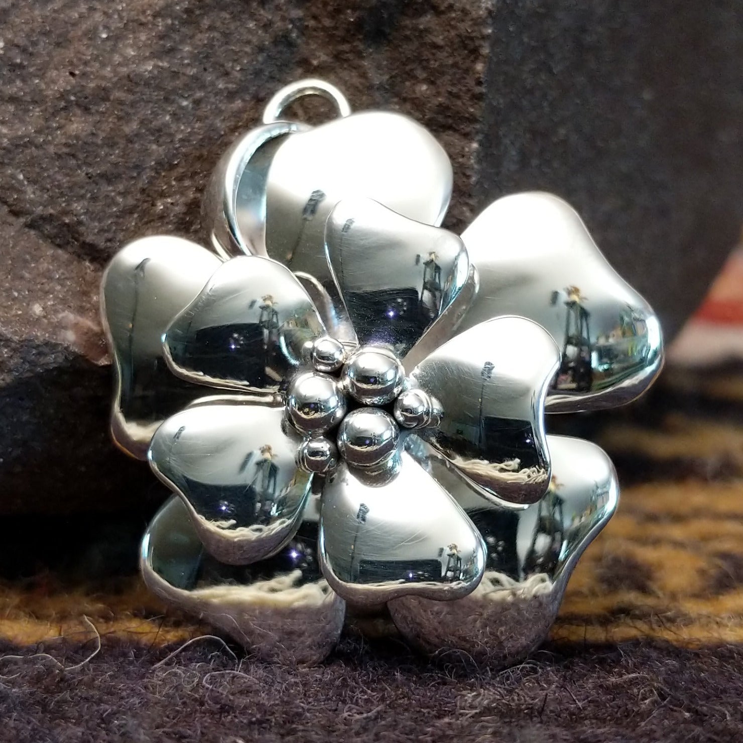 Handcrafted sterling silver pendant by Artie Yellowhorse featuring a detailed dogwood flower design in a polished Southwestern Native American style.