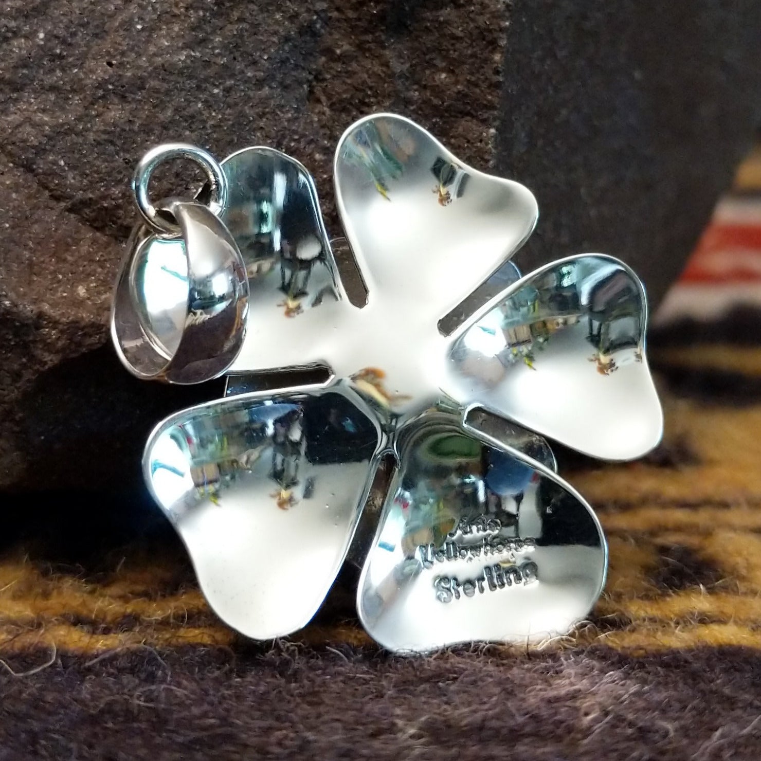 Handcrafted sterling silver pendant by Artie Yellowhorse featuring a detailed dogwood flower design in a polished Southwestern Native American style.  Back view showcasing artisan and Sterling Silver stamp.