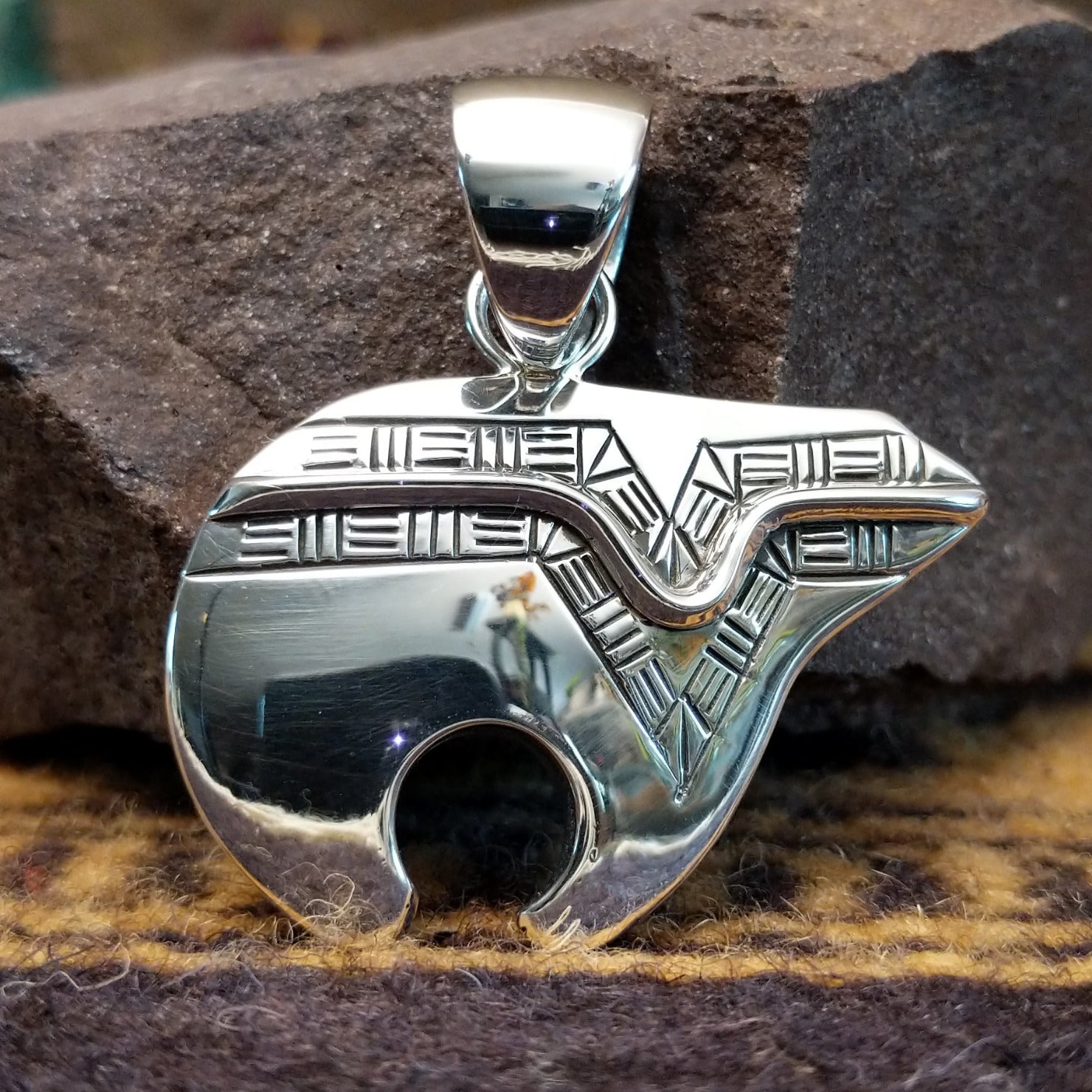 Handcrafted sterling silver pendant by Artie Yellowhorse featuring a stylized spirit bear design in a polished Southwestern Native American style.