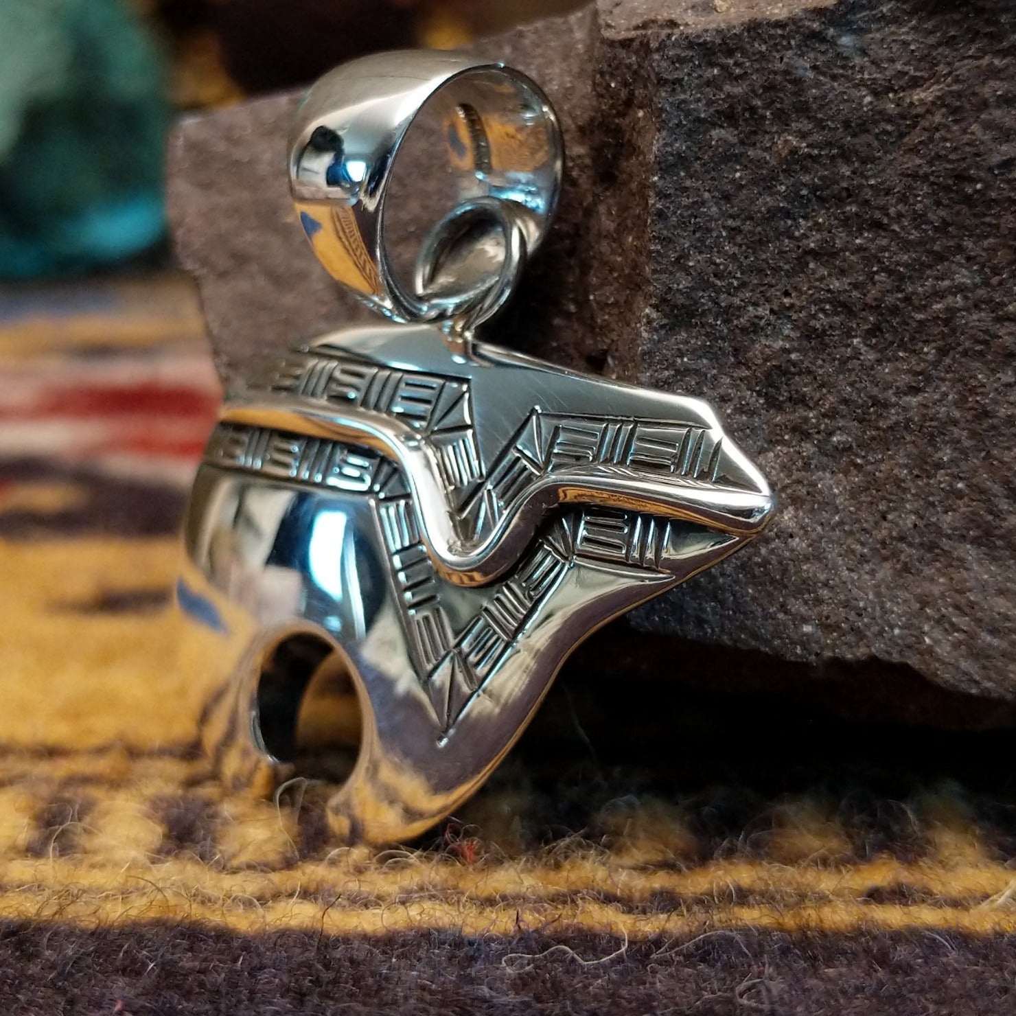 Handcrafted sterling silver pendant by Artie Yellowhorse featuring a stylized spirit bear design in a polished Southwestern Native American style.  Side view.
