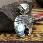 Handcrafted sterling silver pendant by Artie Yellowhorse featuring a stylized spirit bear design in a polished Southwestern Native American style.  Side view.