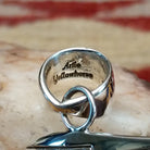 Handcrafted sterling silver pendant by Artie Yellowhorse featuring a stylized spirit bear design in a polished Southwestern Native American style.  View of bail showcasing artisan stamp.