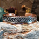 Handcrafted copper and sterling silver cuff bracelet by Robert Little featuring chevron-stamped detailing in a traditional Southwestern Native American design.