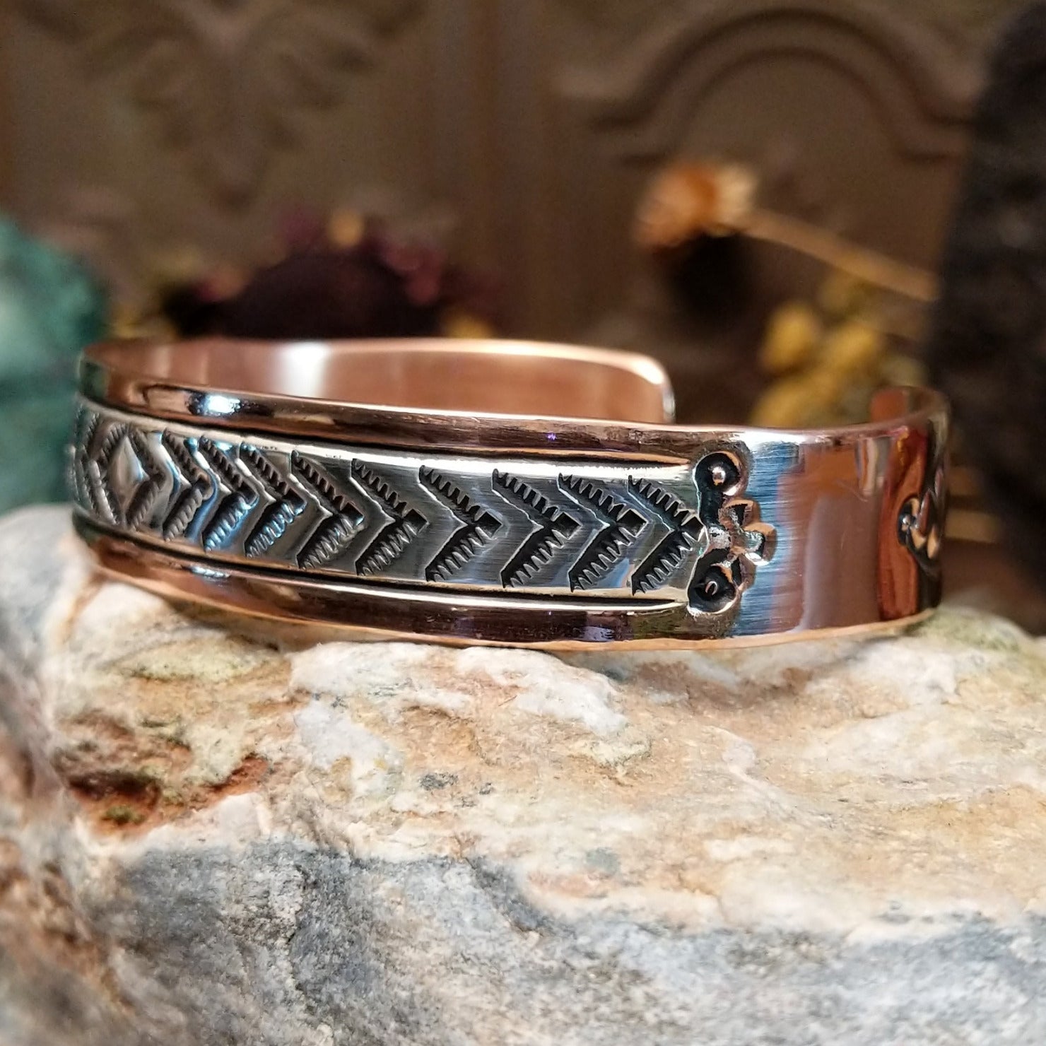 Handcrafted copper and sterling silver cuff bracelet by Robert Little featuring chevron-stamped detailing in a traditional Southwestern Native American design.  Side view.