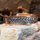 Handcrafted copper and sterling silver cuff bracelet by Robert Little featuring chevron-stamped detailing in a traditional Southwestern Native American design.  Side view.