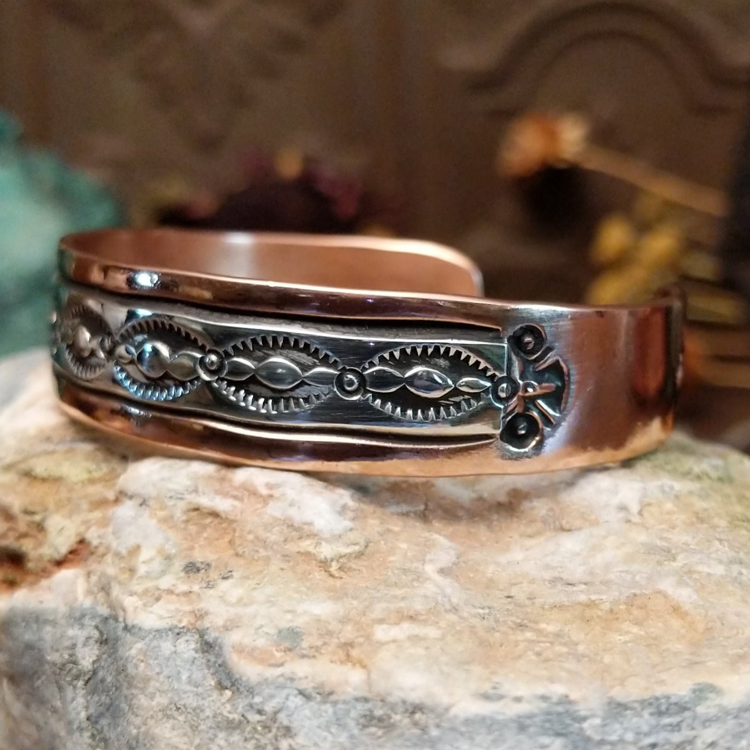 Handcrafted copper and sterling silver cuff bracelet by Navajo artisan Robert Little featuring wavy stamped detailing in a traditional Southwestern design.  Side view.