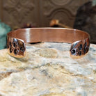 Handcrafted copper and sterling silver cuff bracelet by Navajo artisan Robert Little featuring bear paw stamped detailing in a traditional Southwestern design.  Underside view.