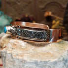 Handcrafted copper and sterling silver cuff bracelet by Navajo artisan Robert Little featuring a turquoise stone and traditional stamped detailing in a Southwestern design.  Side view.
