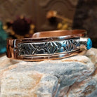 Handcrafted copper and sterling silver cuff bracelet by Navajo artisan Robert Little featuring a turquoise stone and traditional stamped detailing in a Southwestern design.  Side view.
