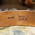Handcrafted copper and sterling silver cuff bracelet by Navajo artisan Robert Little featuring a turquoise stone and traditional stamped detailing in a Southwestern design.  Navajo and Sterling Silver stamp.