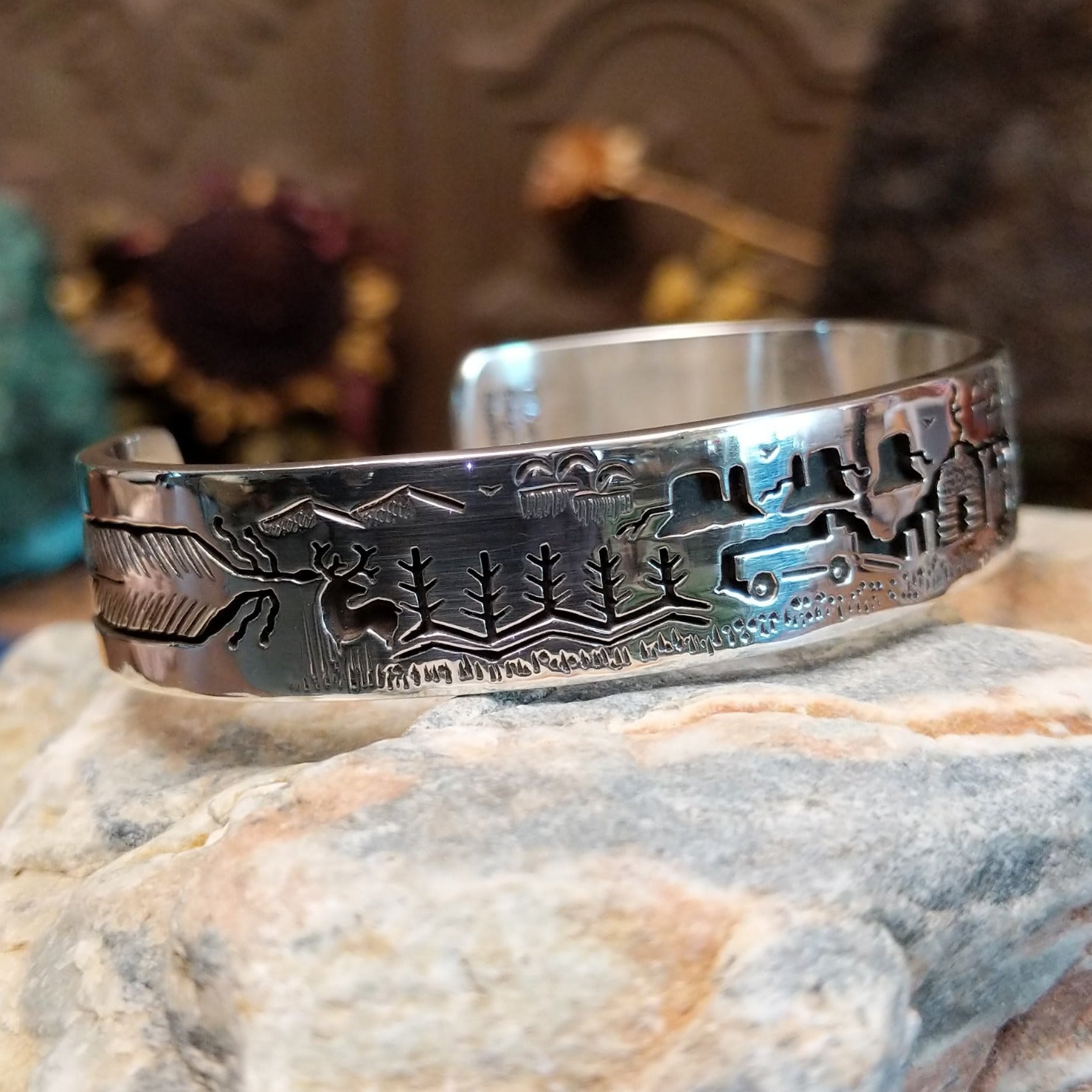 Handcrafted sterling silver cuff bracelet by Navajo artist Gilbert Begay featuring an engraved landscape storyteller design with traditional Southwestern details.  Side view.