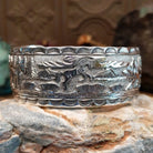 Handcrafted sterling silver cuff bracelet by Navajo artist June Delgarito featuring an engraved horse and landscape scene in a traditional Southwestern design.