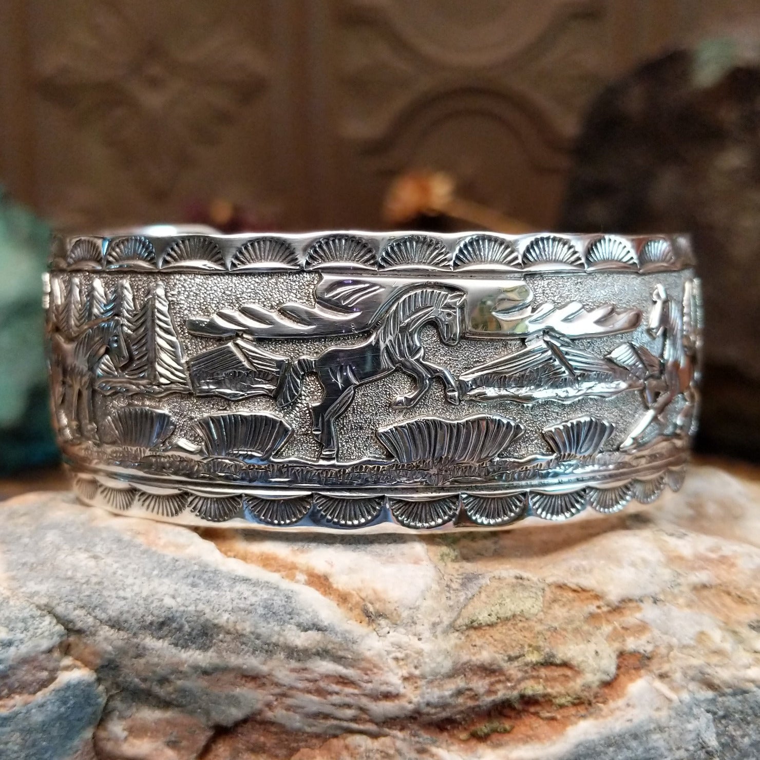 Handcrafted sterling silver cuff bracelet by Navajo artist June Delgarito featuring an engraved horse and landscape scene in a traditional Southwestern design.
