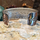 Handcrafted sterling silver cuff bracelet by Navajo artist June Delgarito featuring an engraved horse and landscape scene in a traditional Southwestern design.  Underside view.