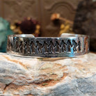 Handcrafted sterling silver cuff bracelet by Navajo artist Gilbert Begay featuring an engraved friendship dance storyteller scene in a traditional Southwestern design.