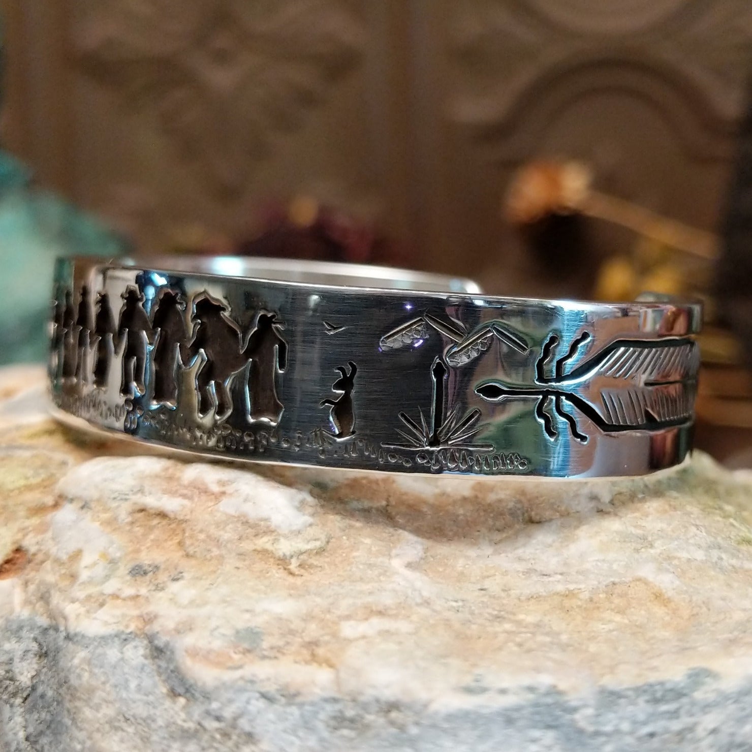 Handcrafted sterling silver cuff bracelet by Navajo artist Gilbert Begay featuring an engraved friendship dance storyteller scene in a traditional Southwestern design.  Side view.