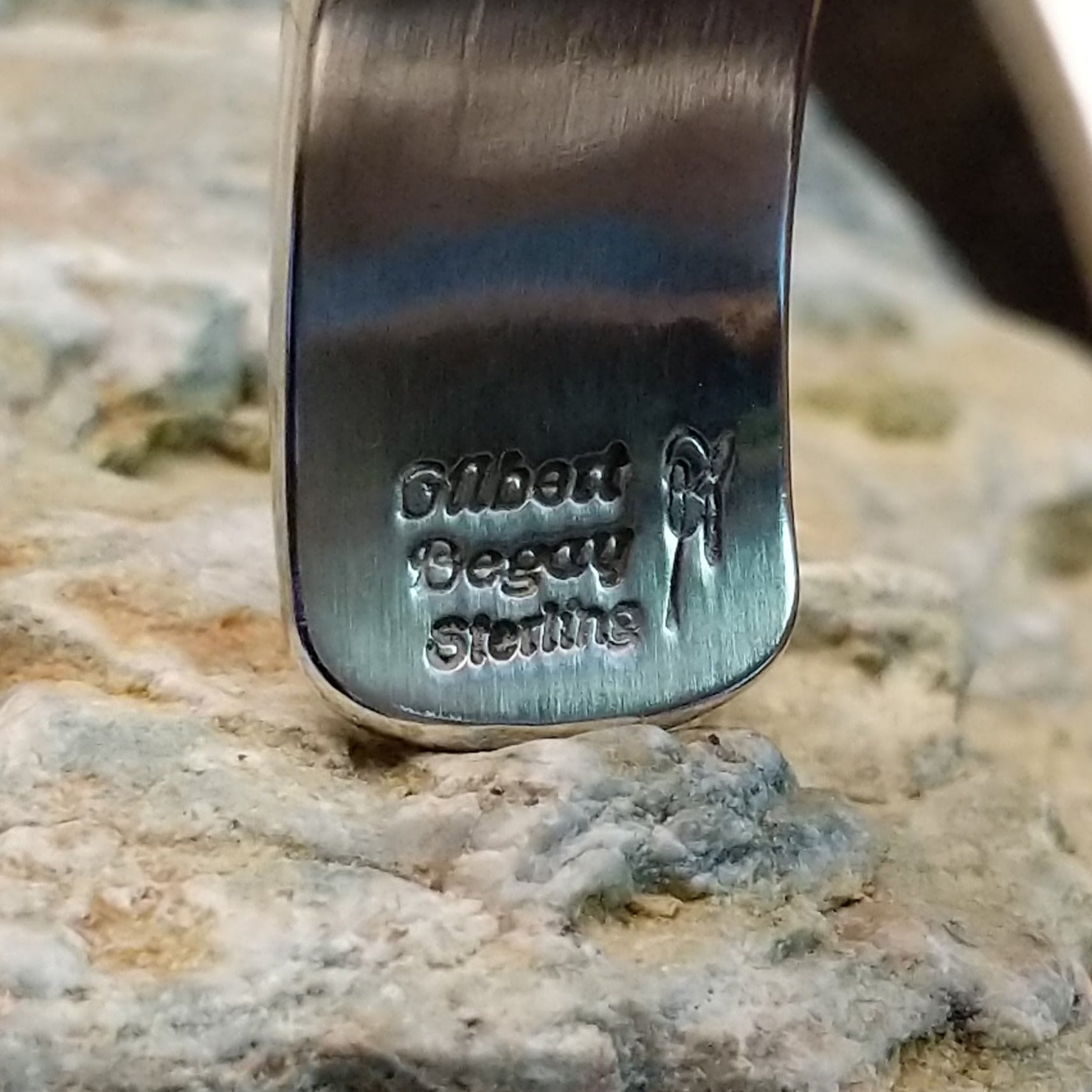 Handcrafted sterling silver cuff bracelet by Navajo artist Gilbert Begay featuring an engraved friendship dance storyteller scene in a traditional Southwestern design.  Artisan and Sterling Silver stamp.