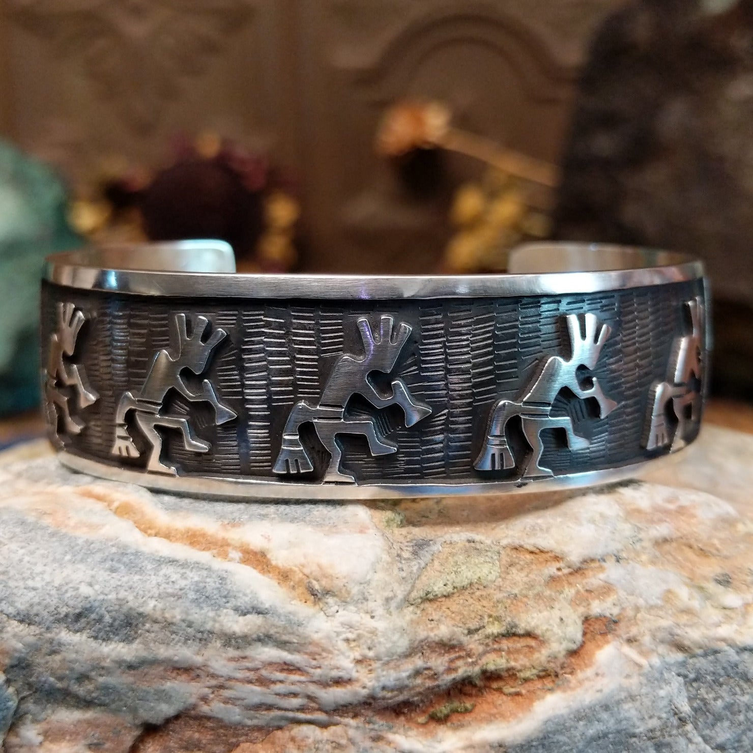 Handcrafted sterling silver cuff bracelet by Hopi artist Melinda Lucas featuring a carved Kokopelli design in a traditional Southwestern style.