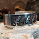 Handcrafted sterling silver cuff bracelet by Hopi artist Melinda Lucas featuring a carved Kokopelli design in a traditional Southwestern style.  Side view.