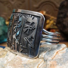 Handcrafted Navajo sterling silver cuff bracelet featuring a detailed Kokopelli design in a traditional Southwestern Native American style.  Side view.