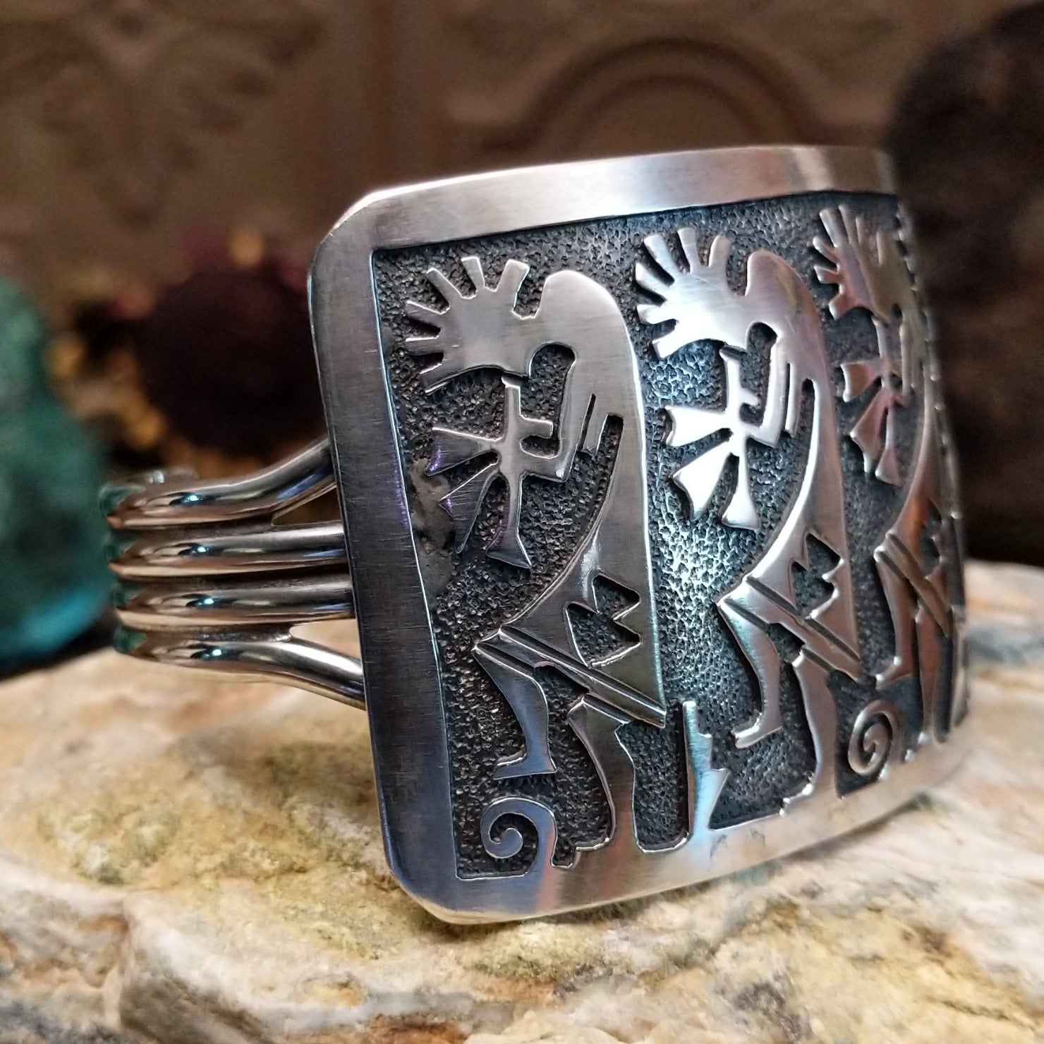 Handcrafted Navajo sterling silver cuff bracelet featuring a detailed Kokopelli design in a traditional Southwestern Native American style.  Side view.