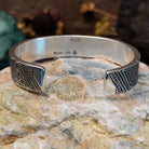 Handcrafted sterling silver cuff bracelet by Elgin Tom featuring geometric pattern detailing in a modern Southwestern Native American design.  Underside view.