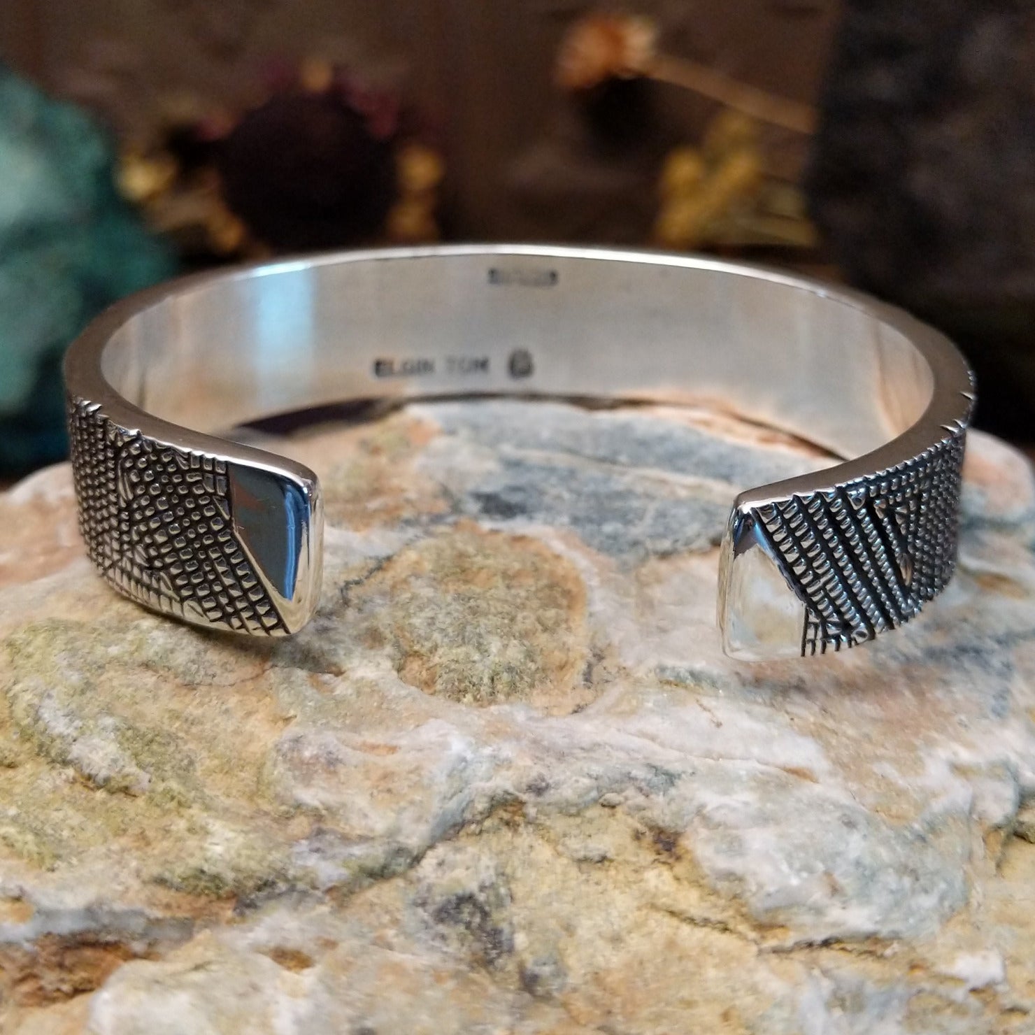 Handcrafted sterling silver cuff bracelet by Elgin Tom featuring geometric pattern detailing in a modern Southwestern Native American design.  Underside view.