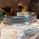 Handcrafted sterling silver cuff bracelet by Sunshine Reeves featuring diamond-stamped geometric detailing in a traditional Navajo Southwestern design.  Side view.