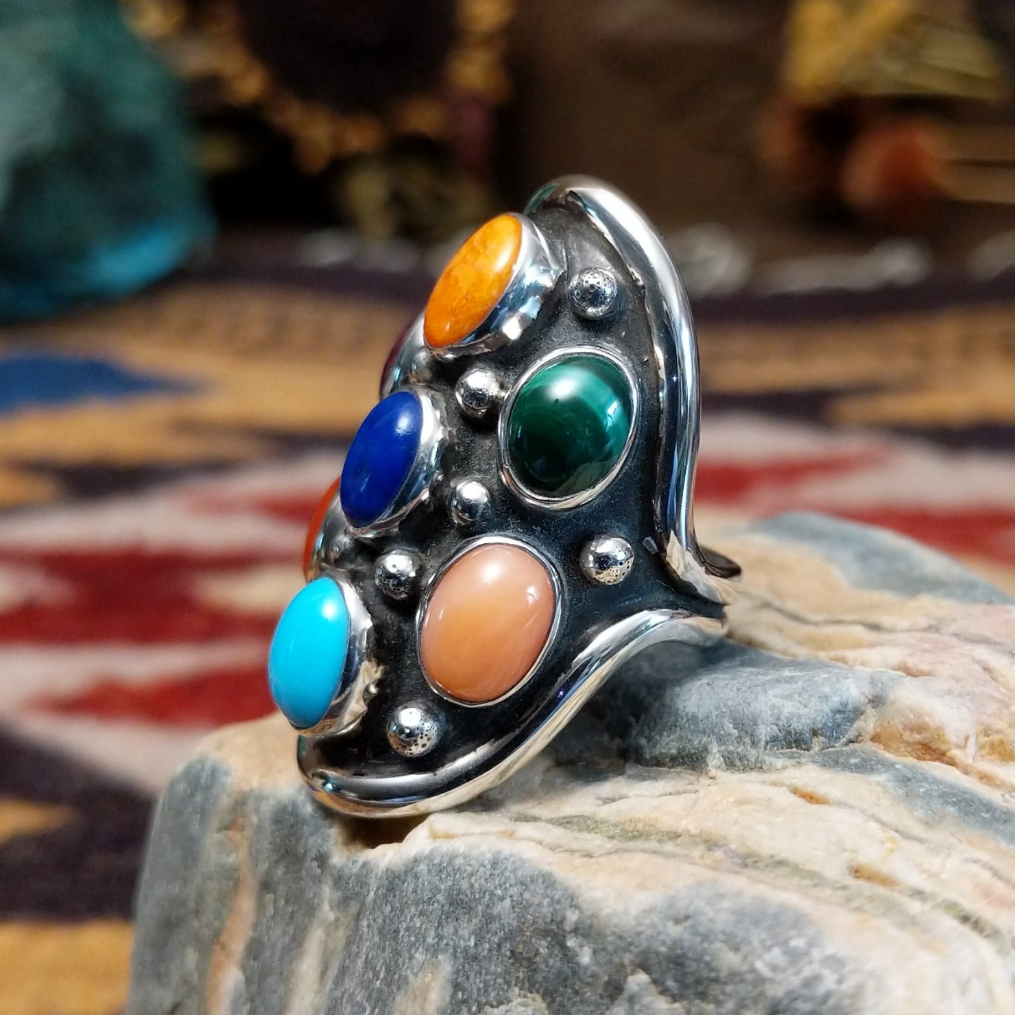 Handcrafted sterling silver multistone ring by Bernice Bonney featuring a colorful arrangement of natural gemstones in a traditional Southwestern Native American design.  Side view.