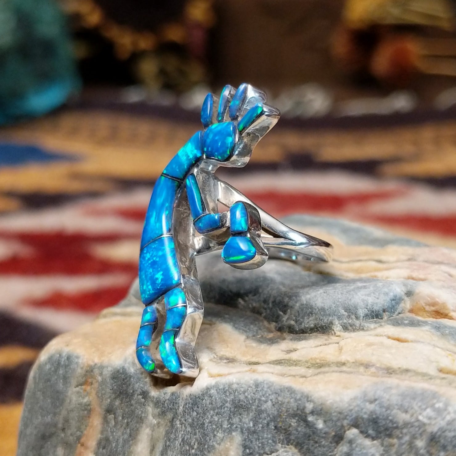 Handcrafted sterling silver ring by James Mason featuring a blue manmade opal and Kokopelli design in a traditional Southwestern Native American style.  Side view.

