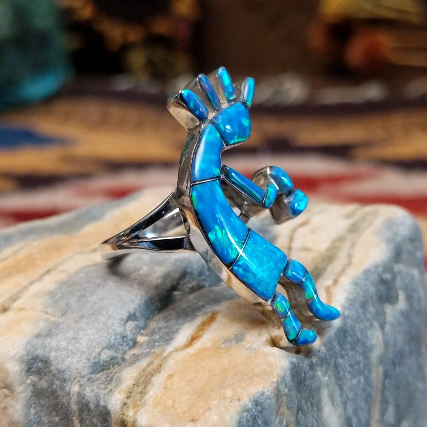 Handcrafted sterling silver ring by James Mason featuring a blue manmade opal and Kokopelli design in a traditional Southwestern Native American style.  Side view.
