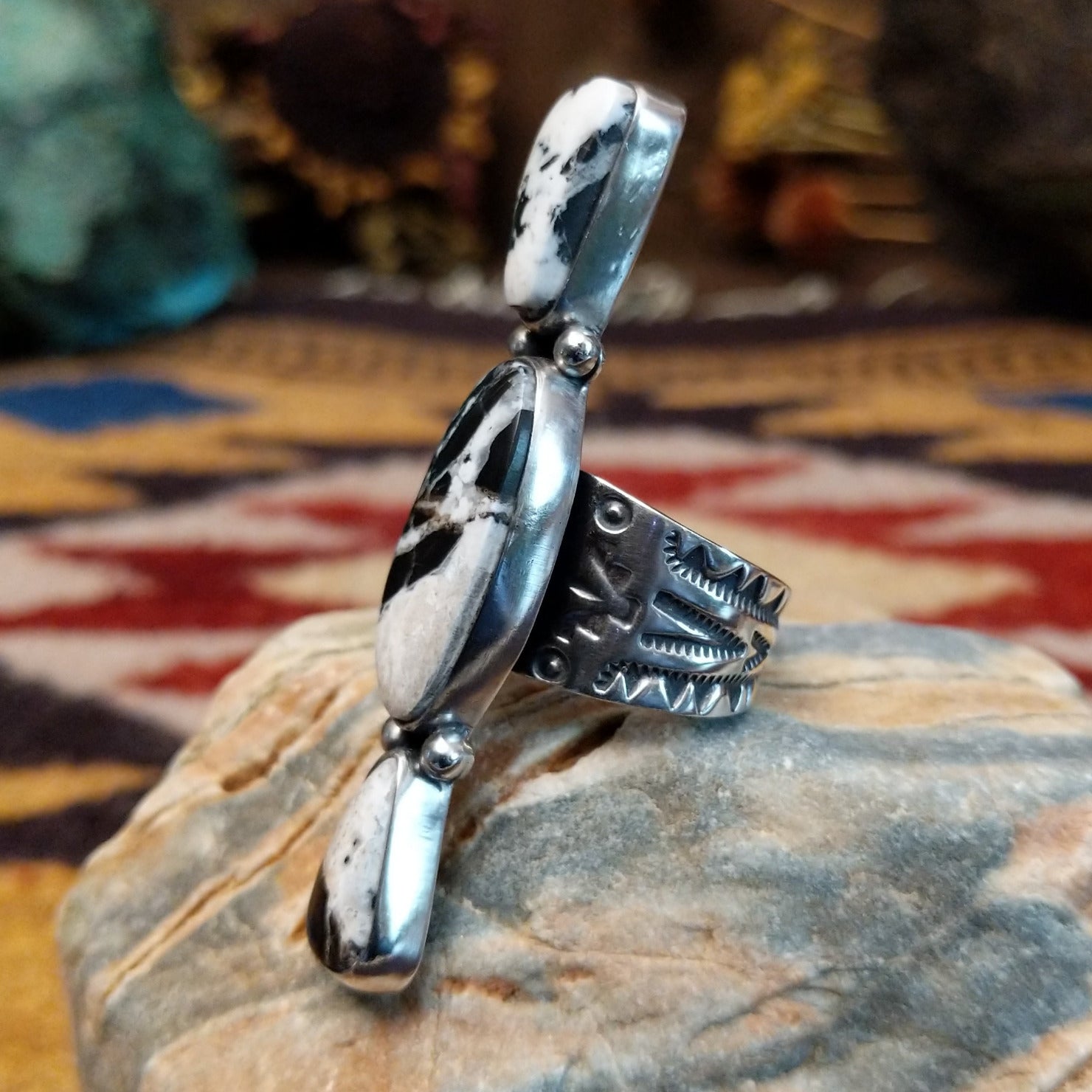 Handcrafted sterling silver ring by Bernyse Chavez featuring an elongated White Buffalo stone with natural black-and-white patterns in a Southwestern Native American design.  Side view.