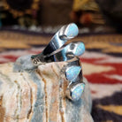 Handcrafted Navajo sterling silver teardrop ring featuring a white manmade opal with iridescent color play in a traditional Southwestern design.  Side view.