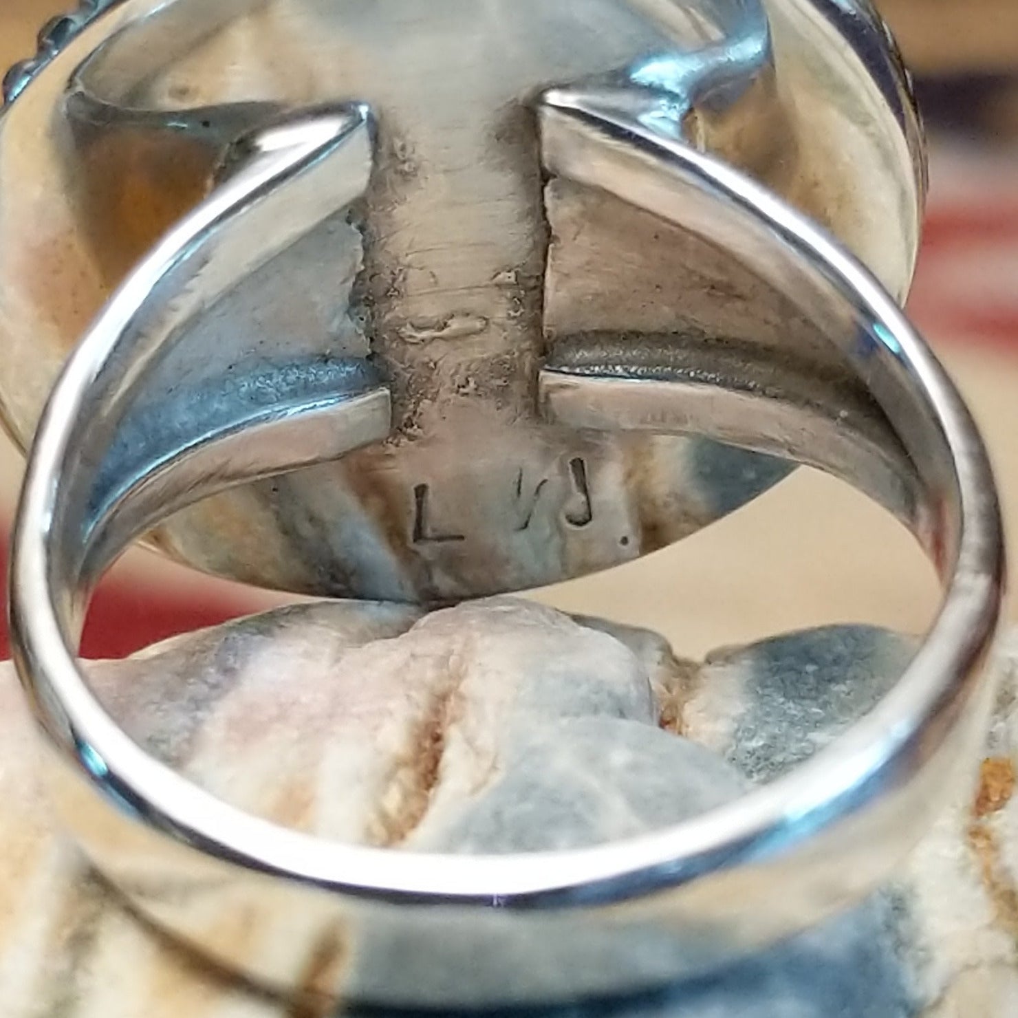 Handcrafted Navajo sterling silver ring by Lucy Jake featuring a turquoise stone with floral inspired traditional Southwestern design.  Artisan stamp.