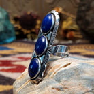Handcrafted sterling silver ring by Toledo featuring three oval lapis stones in a vertical arrangement with geometric silver accents in a traditional Southwestern Native American design.  Side view.