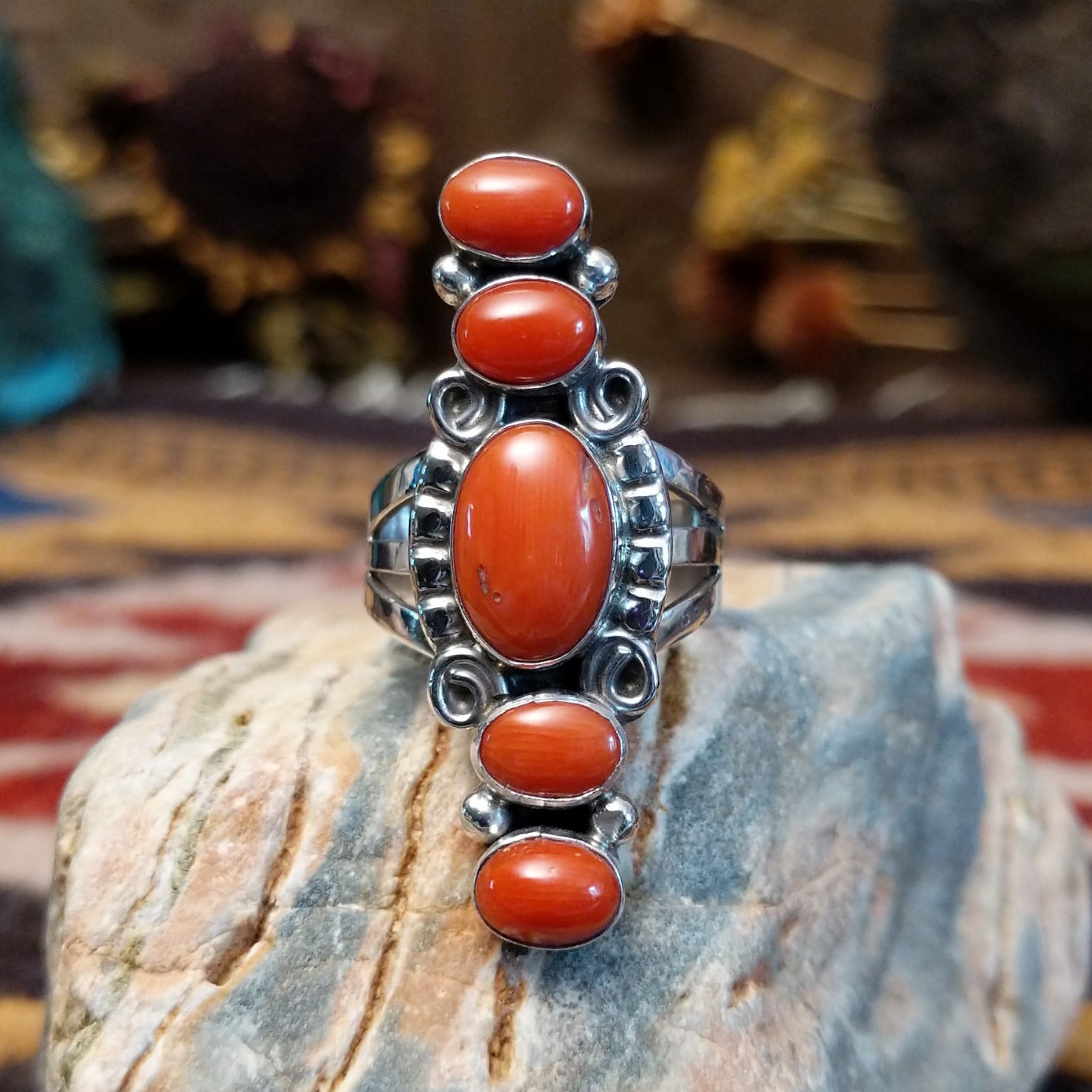 Handcrafted Navajo sterling silver ring by D.W. featuring multiple red coral stones arranged vertically with decorative silver scrollwork and traditional Southwestern detailing.