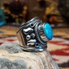 Handcrafted Navajo sterling silver ring by Murphy Platero featuring a raised oval turquoise stone surrounded by twisted wire, beadwork, and traditional Southwestern silver detailing.  Side view.