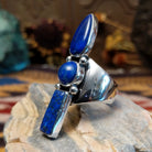 Handcrafted Navajo sterling silver ring by V.T. featuring a deep blue lapis stone in an abstract Southwestern design with intricate silver detailing.  Side view.
